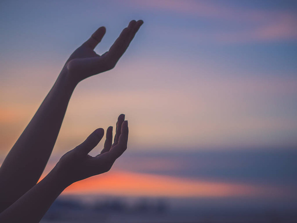 Zbliżenie kobieta ręce modląc się o błogosławieństwo od Boga podczas zachodu słońca - Zdjęcie, obraz