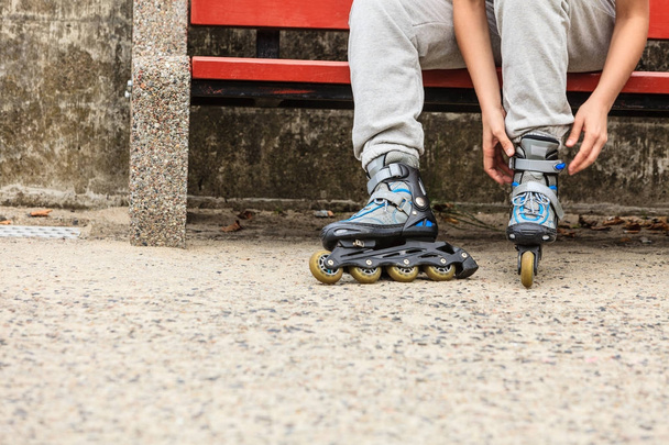 Woman putting on roller skates outdoor. - Foto, Imagem