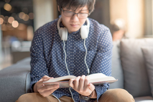 Mladý muž univerzitní student čtení knih na pohovce - Fotografie, Obrázek