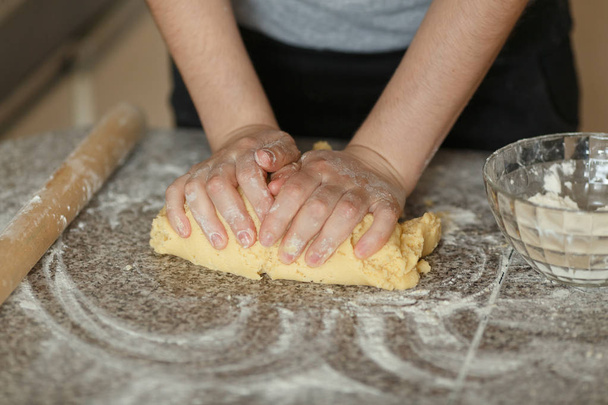 Panadero manos amasando masa en harina en la mesa - Foto, imagen