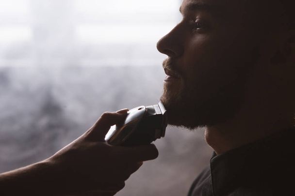 Shaving stylish man closeup. Barbershop backdrop - Photo, Image