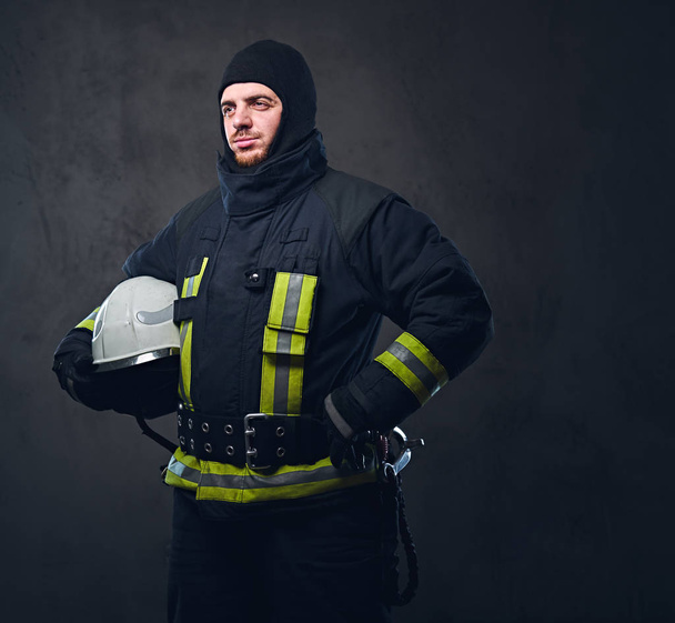 Пожарный держит шлем безопасности
. - Фото, изображение