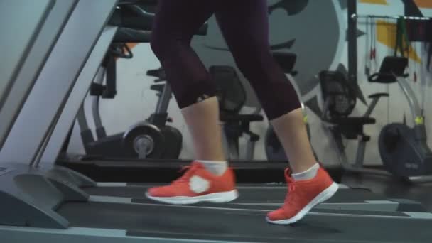 Lähikuva naisten jalka käynnissä juoksumatto moderni kuntokeskus tai kuntosali
 - Materiaali, video