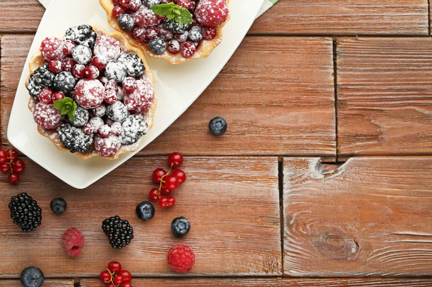 Tasty tartlet with berries and powdered sugar   - 写真・画像