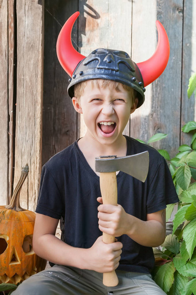 Niño en casco vikingo con cuernos
 - Foto, Imagen