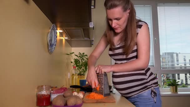 Pregnant future mother woman shredder carrot vegetables and eat - Footage, Video