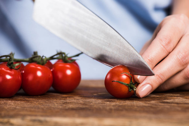 Vrouw snijden cherry tomaten - Foto, afbeelding
