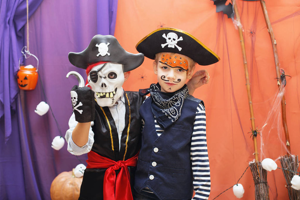 Two little boys in different pirate costumes with faceart are ha - Zdjęcie, obraz