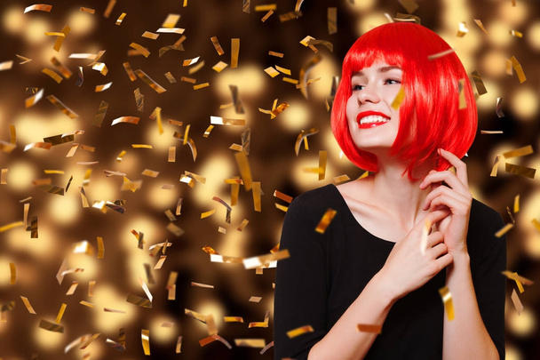 Young pretty woman in a red wig celebrating and having fun at New Year party.   - Valokuva, kuva