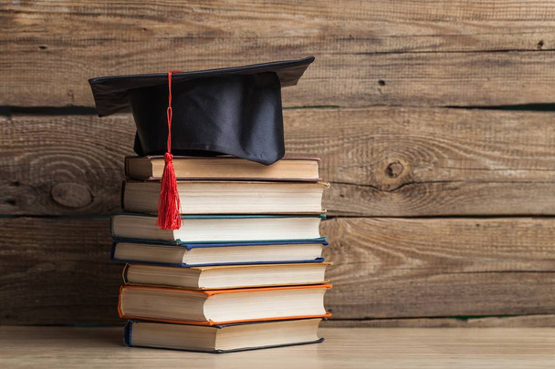 Graduation hat and stacks of books, close-up view - Fotoğraf, Görsel