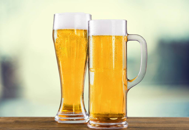 Cold beer in glasses on bokeh background  - Photo, image