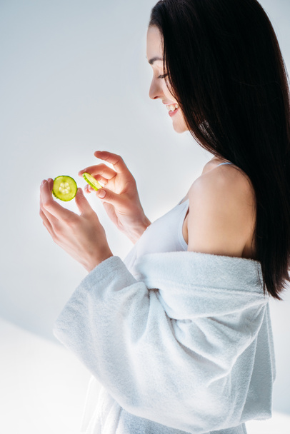 woman in bathrobe holding slices of cucumber - Photo, Image