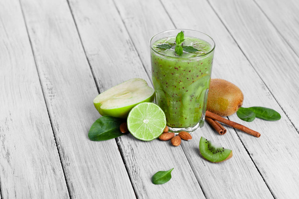 top view of glass of smoothie from kiwi, apple, and lime with mint on a gray wooden background. - Photo, Image