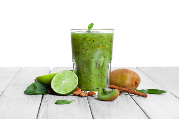 top view of glass of smoothie from kiwi, apple, and lime with mint on a gray wooden background. - Fotó, kép