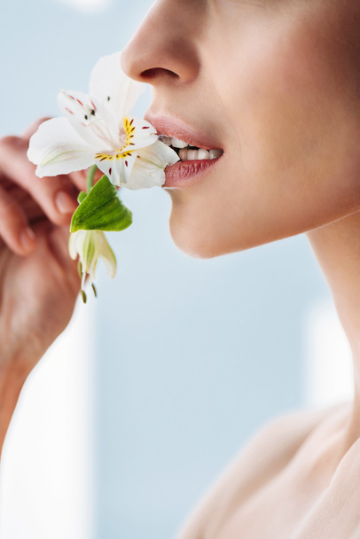 woman with fresh skin with lily in lips - Фото, зображення