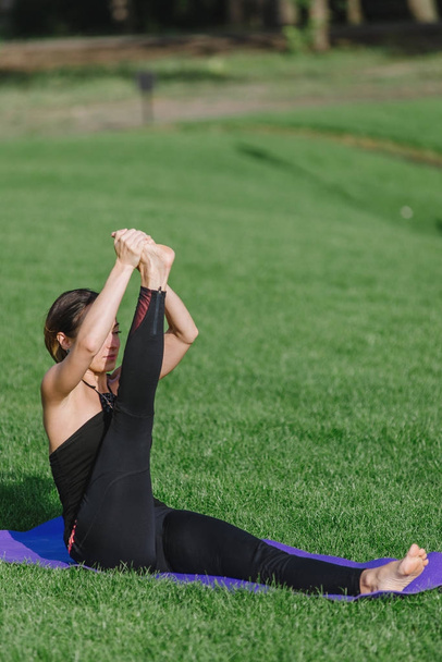 genç kadın sonbaharda sabah parkta yoga yaparken. - Fotoğraf, Görsel