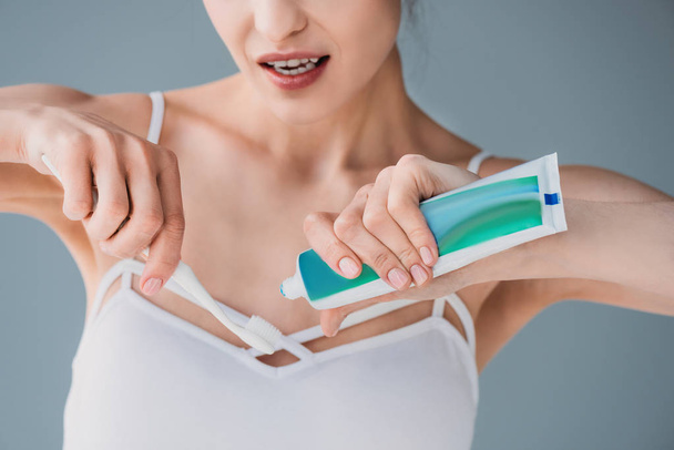Frau drückt Zahnpasta auf Bürste - Foto, Bild