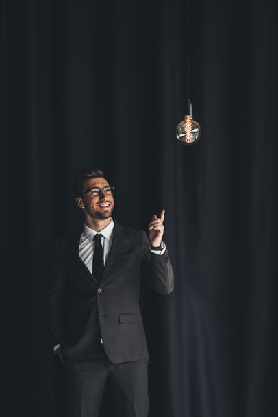 handsome businessman with lightbulb - Фото, изображение