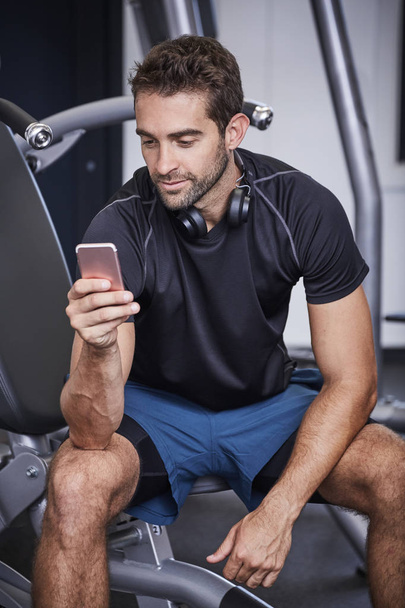 Texting athlete taking a break in gym - Фото, зображення