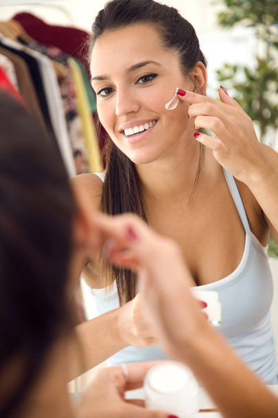 Belle jeune femme prenant soin de sa peau près du miroir dans le bain
 - Photo, image