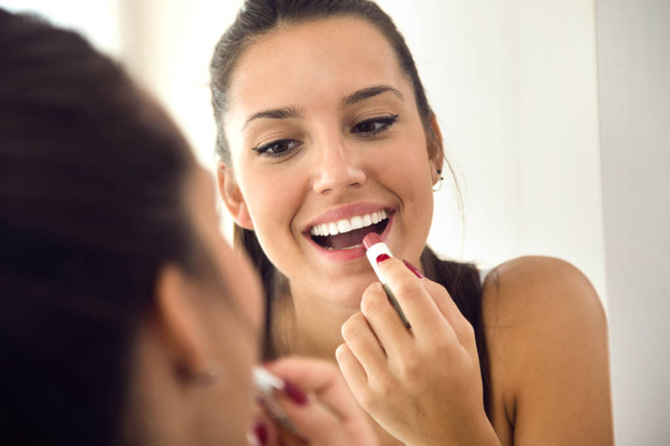 Beautiful young woman making make-up near mirror at home. - Foto, Imagen