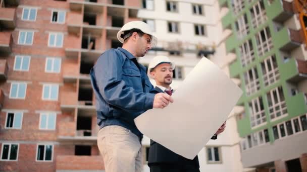 hombres de negocios en cascos en la construcción de edificios
 - Metraje, vídeo