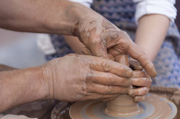 Производство керамики. Руки, работающие на гончарном круге
 - Фото, изображение