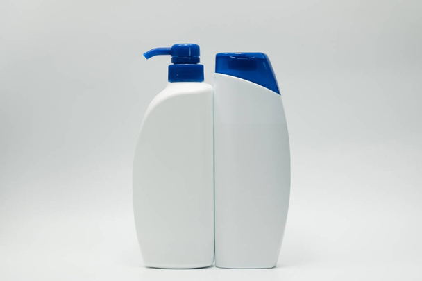 Sampon és kondicionáló palackok másol hely, fehér alapon kék kupakkal. Hirdessen sampon és kondicionáló koncepció használata - Fotó, kép