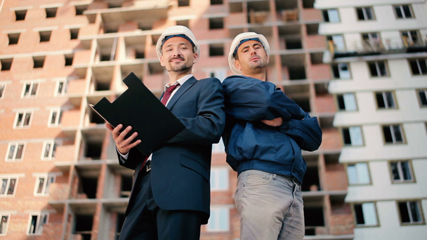 businessmen in helmets on buildings construction - Metraje, vídeo