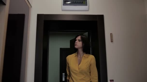 brunette businesswoman in yellow shirt with suitcase enter hotel room - Materiał filmowy, wideo
