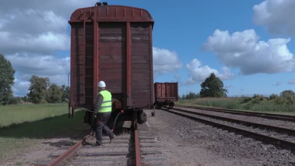 Robotnik kolejowy sprawdza dachu wagonu - Materiał filmowy, wideo