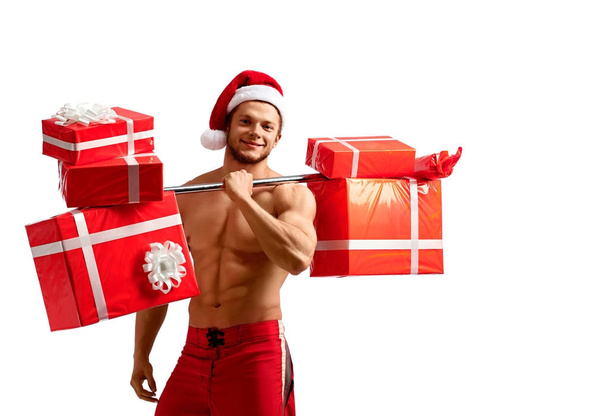 Ripped Santa holding a barbell with presents - Photo, image