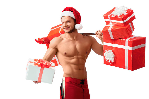 Ripped Santa Claus holding barbell and giving presents - Photo, image