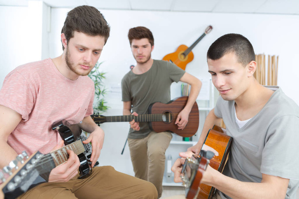 musicians with guitar at music store - Photo, Image