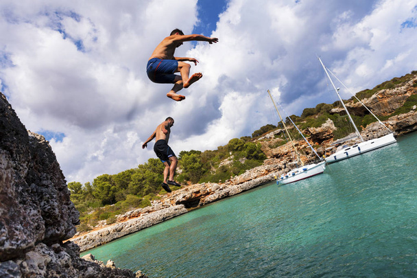 Sprung von Klippen auf der sonnigen Cala Sa Nau, Mallorca, Spanien - Foto, Bild