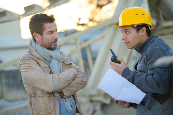 entrepreneur and builder on building site using walkie talkie - Фото, зображення