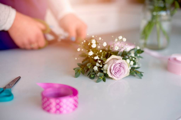 Жінка власник квіткового магазину готує букет з рожевих троянд
 - Фото, зображення