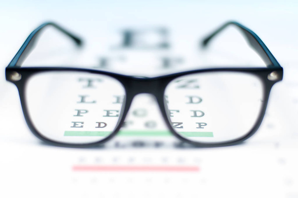 Eye vision test chart seen through eye glasses. - Photo, image