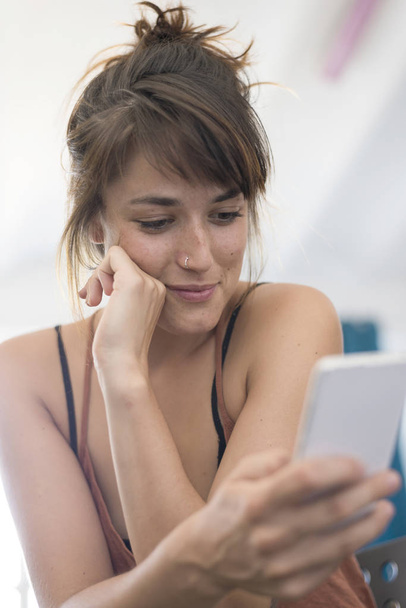 Portrait of happy young businesswoman using mobile phone in offi - Fotografie, Obrázek