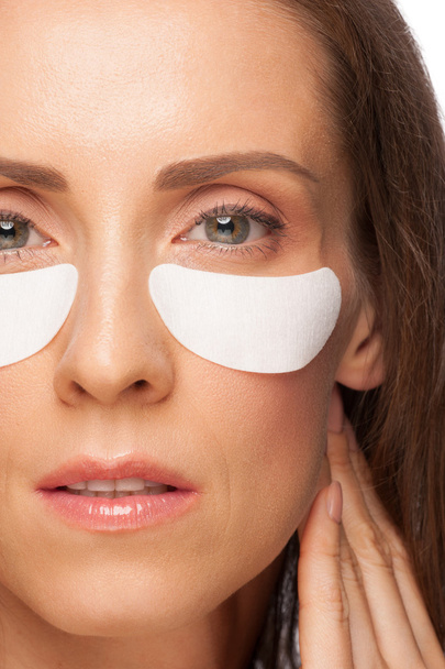 Woman applying gel eye mask - Foto, afbeelding