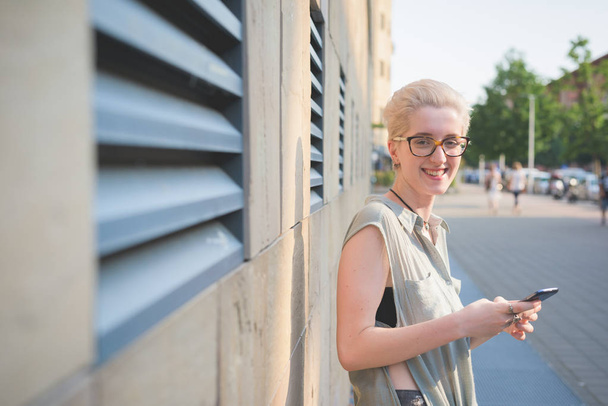 молодая женщина на открытом воздухе держа смартфон глядя на камеру - технологии, социальные сети, концепция счастья
  - Фото, изображение