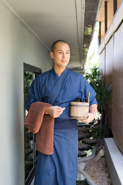 Onsen series: Asian man holding wooden bucket in ryokan - Фото, изображение