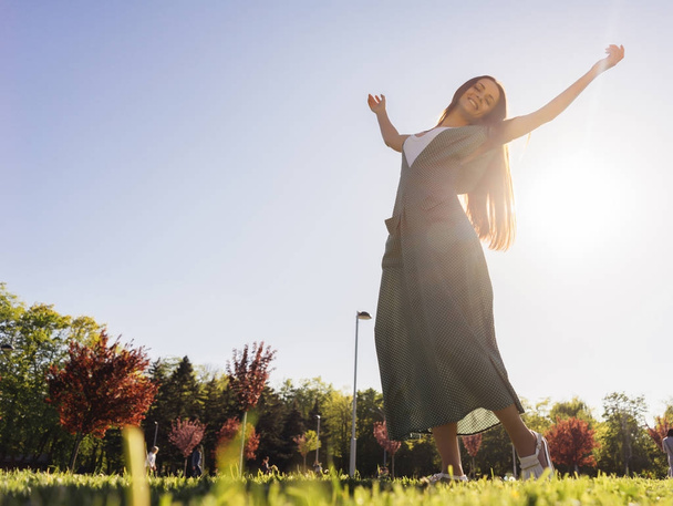 Χαρούμενη και ευτυχισμένη γυναίκα στο γρασίδι μια εξωτερική, απολαμβάνουν τη ζωή, καλοκαίρι - Φωτογραφία, εικόνα
