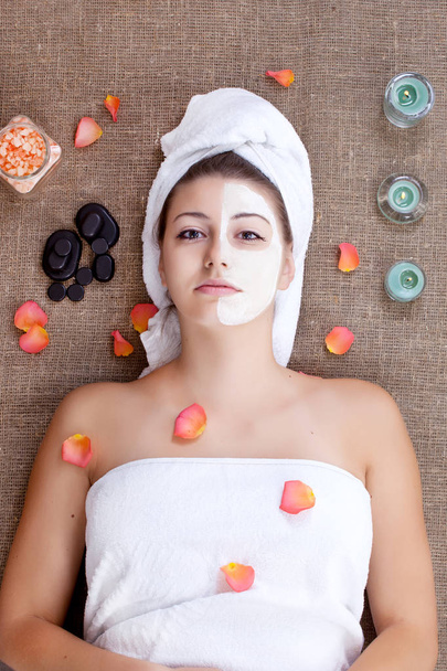 Mädchen mit Gesichtsmaske auf einer Steintherapie, Hot Stone Massage - Foto, Bild