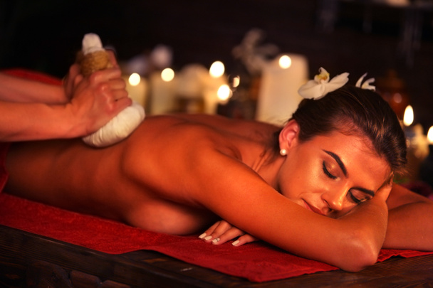 Regalos de spa de masaje de mujer en el salón de spa. Las hembras tienen hierbas terapia de bola caliente
. - Foto, imagen