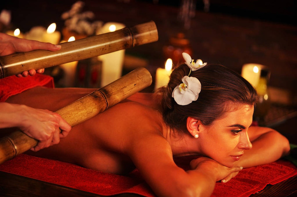 Bamboo massage of woman in spa salon. Interior oriental therapy. - Photo, Image