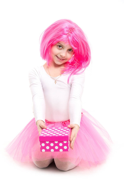 Small girl with gift box with red bow in pink skirt. - Photo, Image