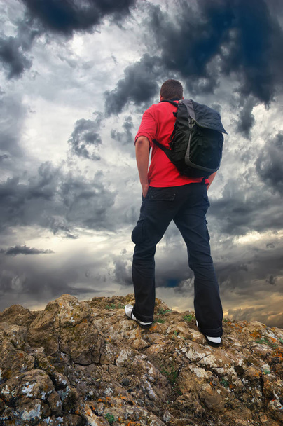 Человек на краю горы. Турист на краю горы и темное небо
 - Фото, изображение