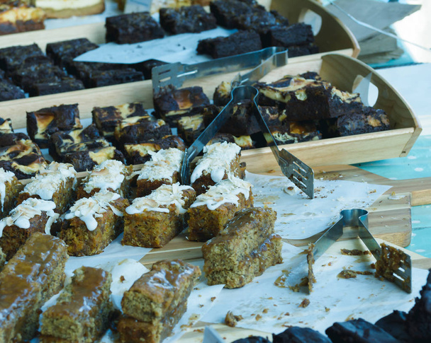 Fatias de bolo exibidas em uma mesa de barracas de mercado A
 - Foto, Imagem