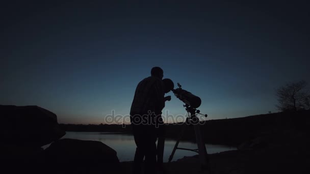 Hombre y niño usando telescopio
 - Imágenes, Vídeo
